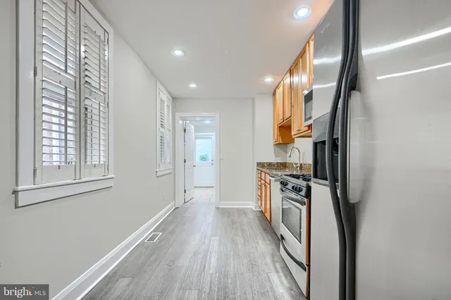 a kitchen with stainless steel appliances granite countertop a sink stove and refrigerator