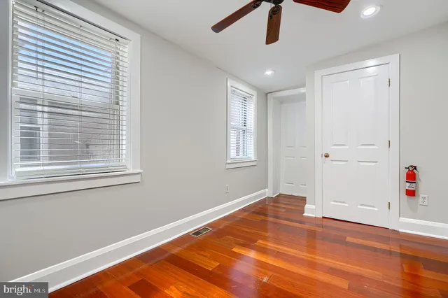 a view of empty room with wooden floor and window