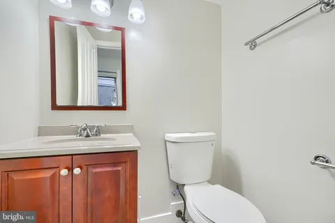a bathroom with a sink a toilet a mirror and shower