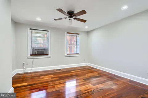 a view of room with wooden floor and ceiling fan