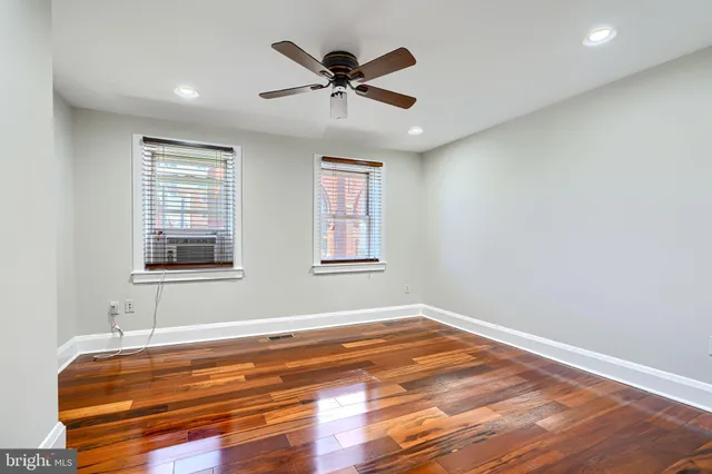 a view of room with wooden floor and ceiling fan