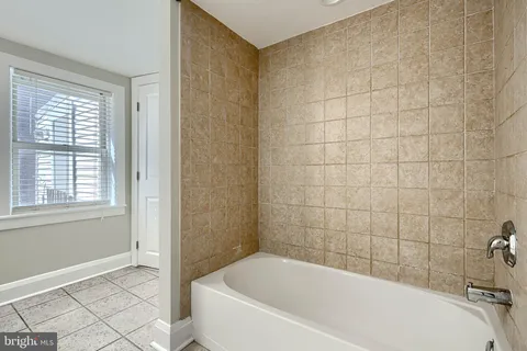 a bathroom with a shower a bathtub and a shower