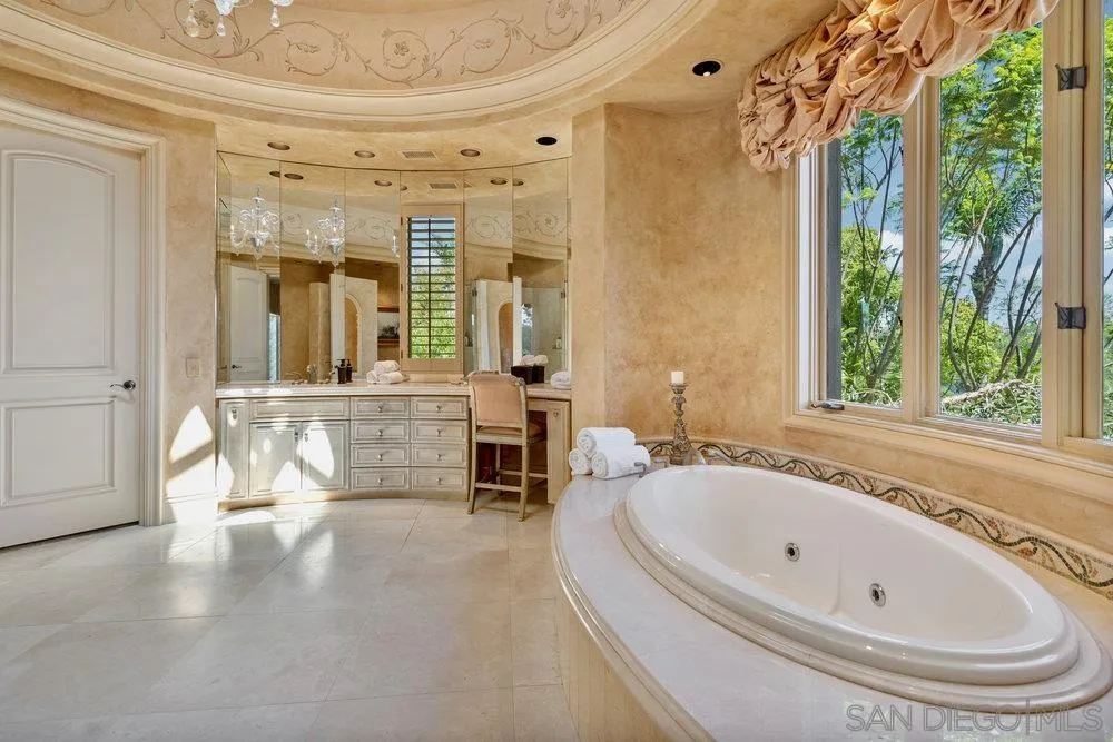 7756 St Andrews Road Rancho Santa Fe, CA 92067 - Photo 25 of 68 a bathroom with a tub a sink and a large mirror