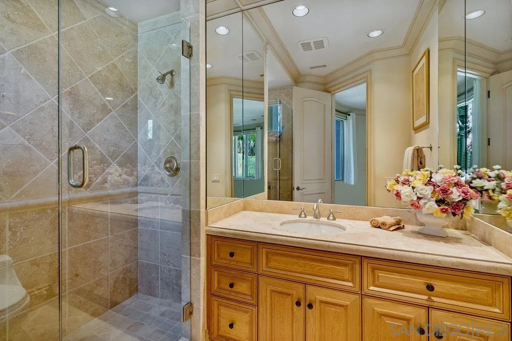 7756 St Andrews Road Rancho Santa Fe, CA 92067 - Photo 31 of 68 a bathroom with a granite countertop sink mirror and shower