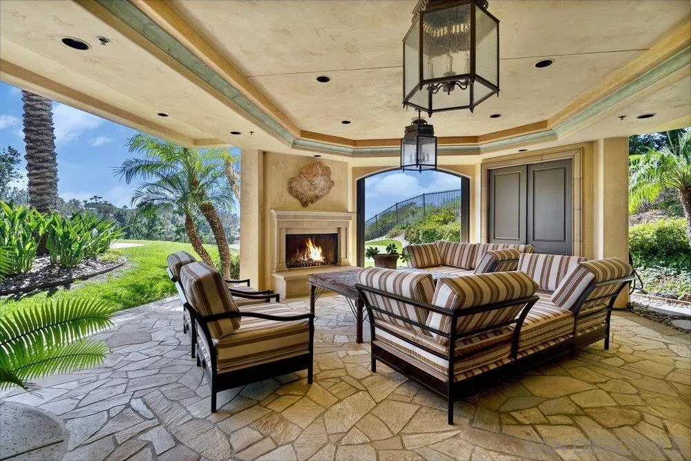 7756 St Andrews Road Rancho Santa Fe, CA 92067 - Photo 63 of 68 a living room with couches a fireplace and a potted plant