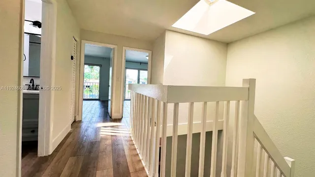a view of a hallway with wooden floor and entryway
