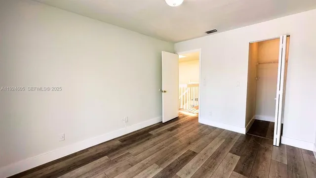 an empty room with wooden floor and entrance
