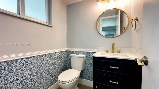 a bathroom with a toilet a sink and a mirror