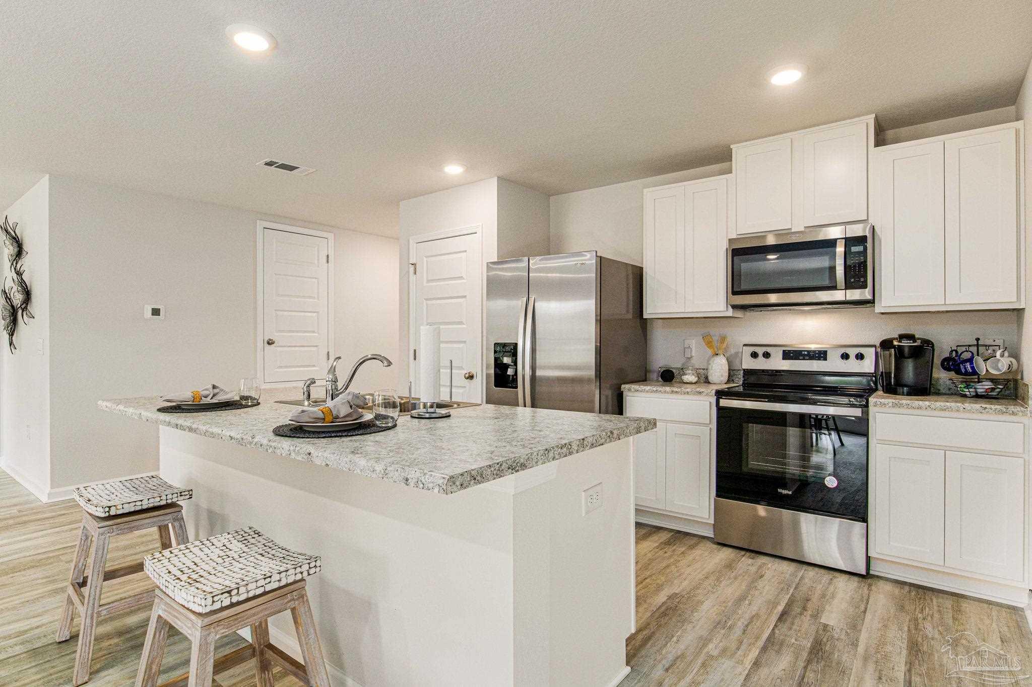 4413 White Birch Court Pace, FL 32571 - Photo 11 of 21 a kitchen with stainless steel appliances granite countertop a stove refrigerator sink and microwave