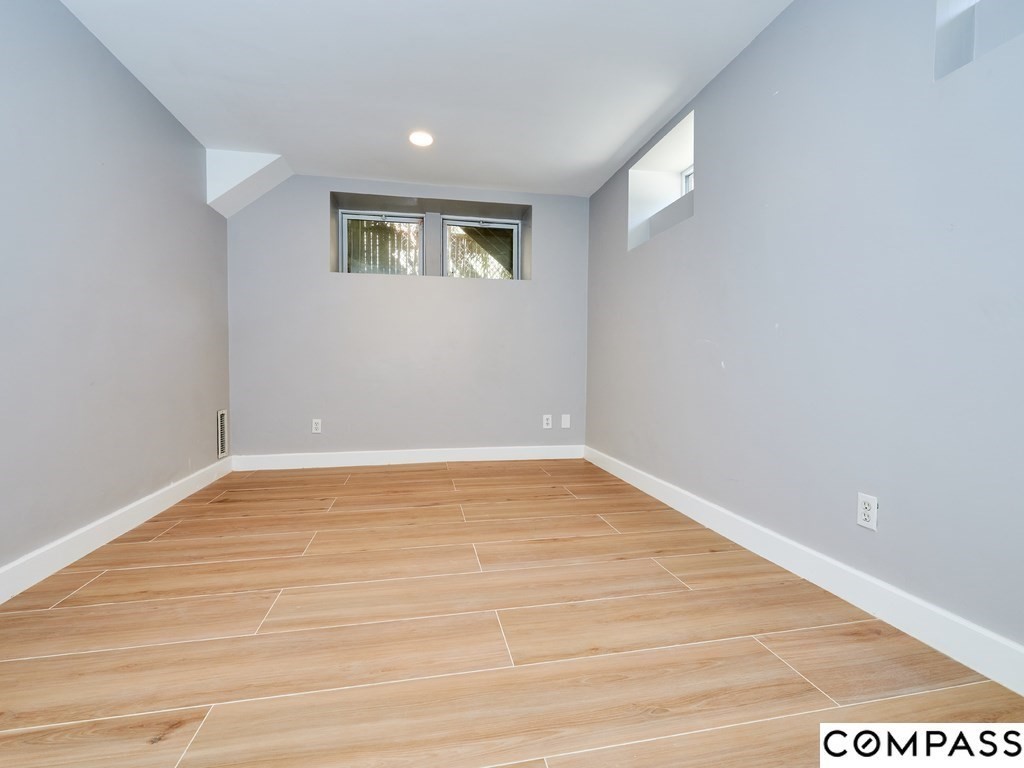 145 Pearl Street, Unit 145 Cambridge, MA 02139 - Photo 22 of 26 a view of an empty room with wooden floor and a window