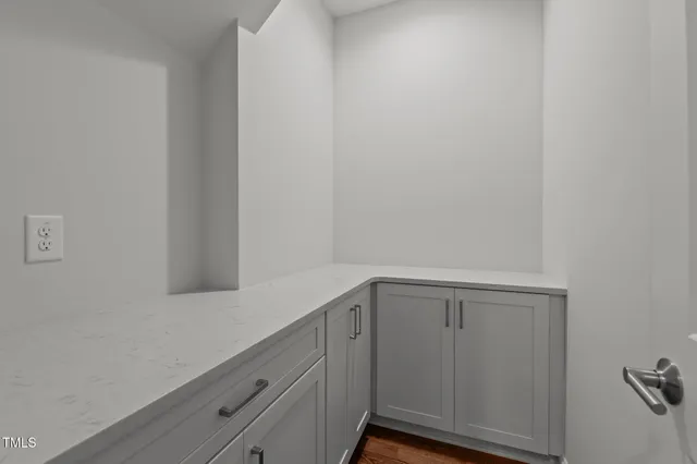 a view of kitchen with stainless steel appliances granite countertop a stove a sink a refrigerator and white cabinets with wooden floor