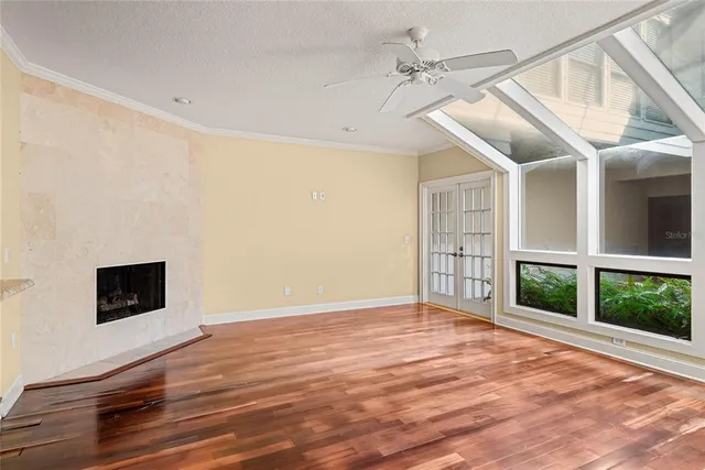 a view of an empty room with a window and wooden floor