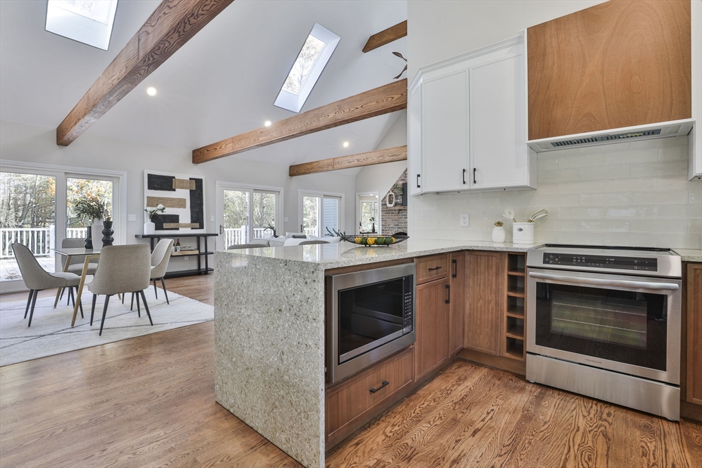 72 Ayer Road Harvard, MA 01451 - Photo 11 of 38 a kitchen with stainless steel appliances granite countertop a stove top oven a sink dishwasher a dining table and chairs with wooden floor