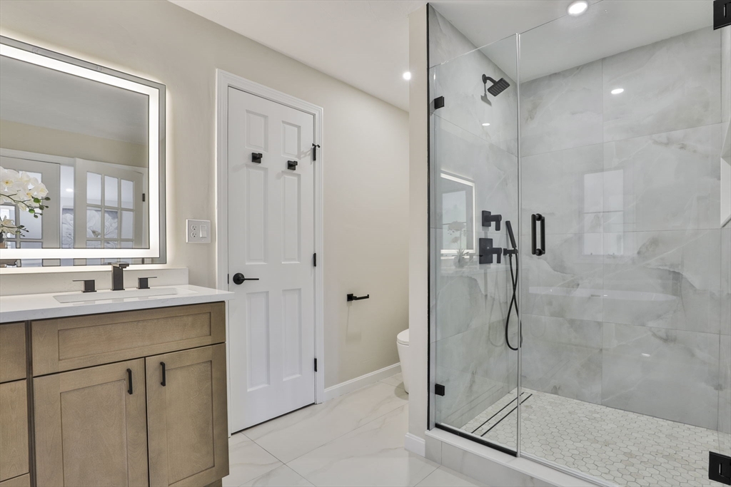 72 Ayer Road Harvard, MA 01451 - Photo 25 of 38 a bathroom with a shower sink and mirror