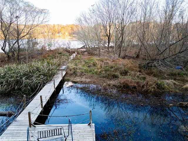 an aerial view of residential houses with outdoor space and lake view