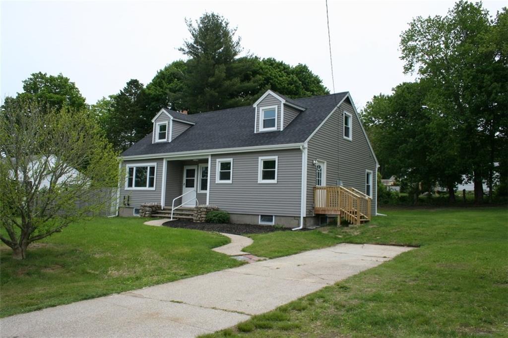 a front view of a house with a yard and trees
