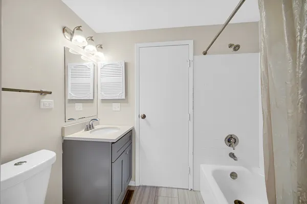 a bathroom with a tub a sink and mirror