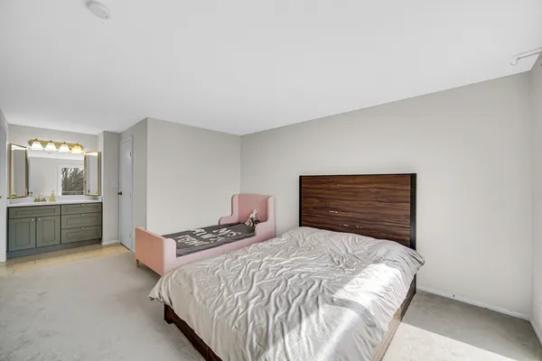 a bedroom with a bed and a refrigerator