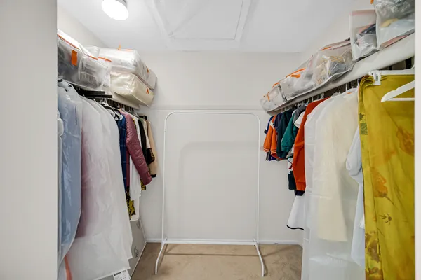 a view of walk in closet with clothes and shoes