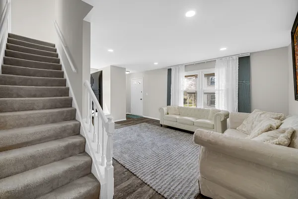 a living room with furniture and stairs