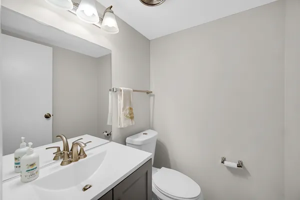 a bathroom with a sink vanity mirror and toilet
