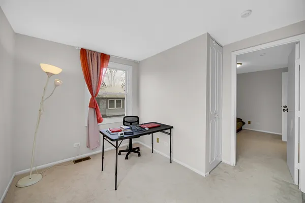 a view of a workspace with furniture and a window