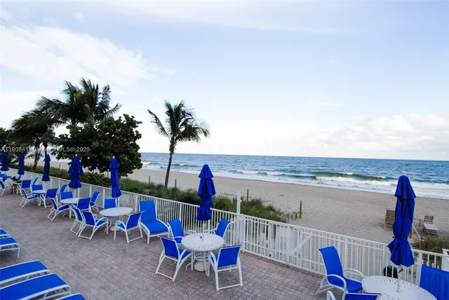 a couple of white chairs sitting next to a bathroom with a sink