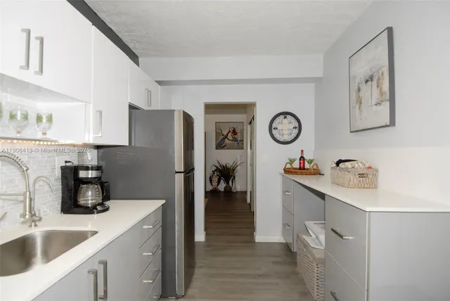 a kitchen with a refrigerator and a sink