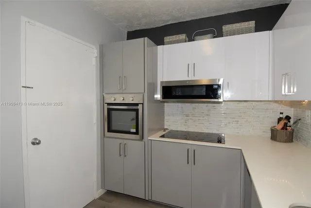 a kitchen with cabinets and steel appliances
