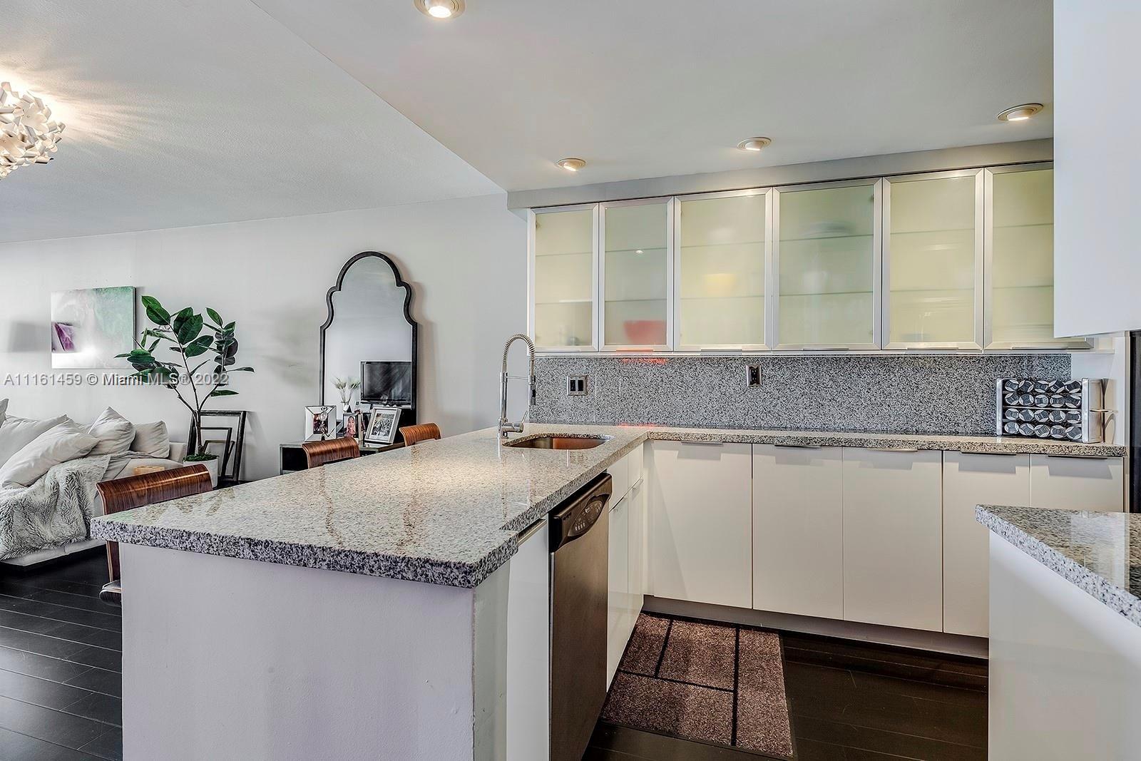 1717 North Bayshore Drive, Unit A1239 Miami, FL 33132 - Photo 5 of 16 a kitchen with granite countertop a sink stainless steel appliances and white cabinets