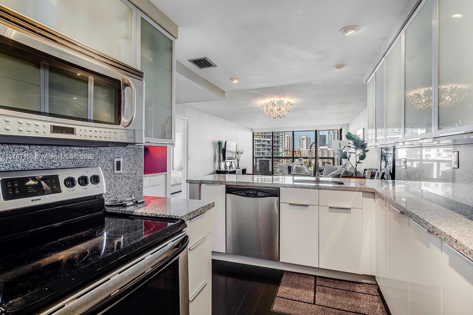 1717 North Bayshore Drive, Unit A1239 Miami, FL 33132 - Photo 6 of 16 a kitchen with a stove and a microwave