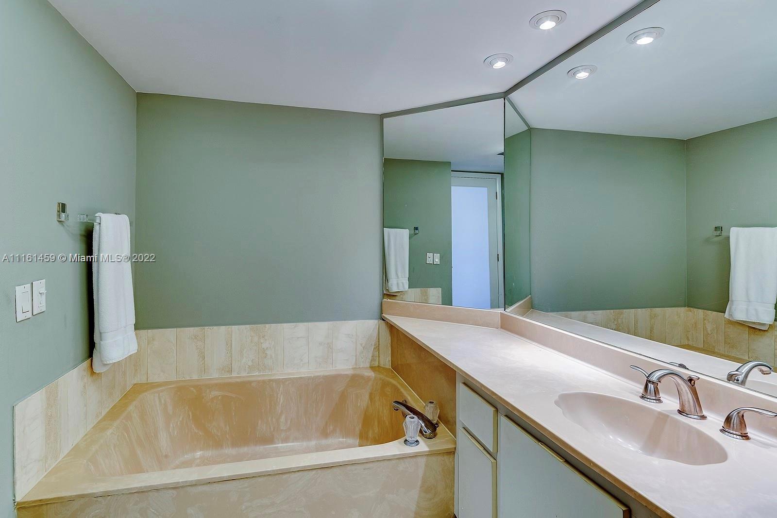 1717 North Bayshore Drive, Unit A1239 Miami, FL 33132 - Photo 9 of 16 a bathroom with a tub sink and mirror