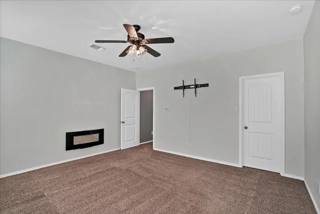 a view of a livingroom with a ceiling fan and window