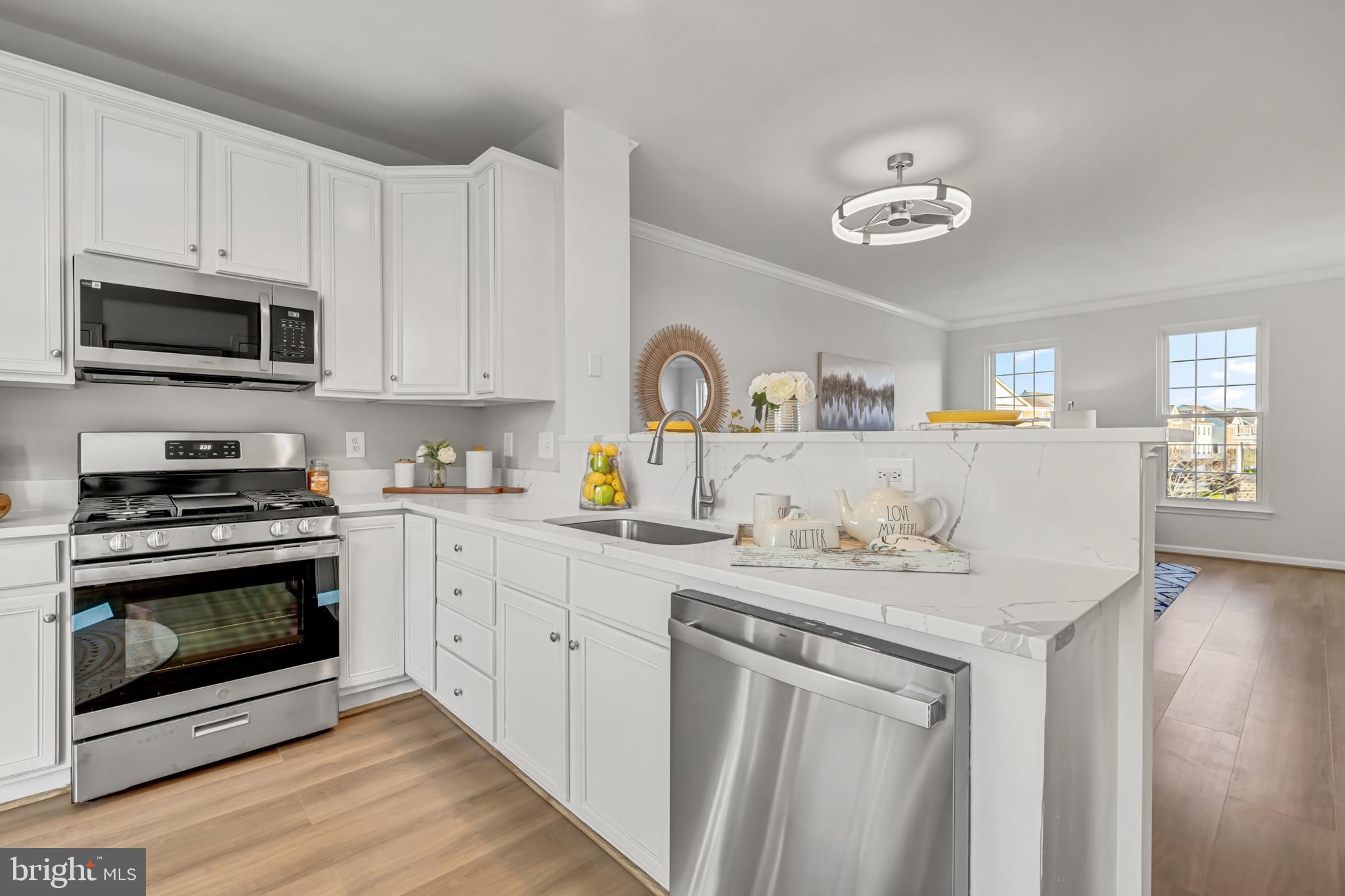 42790 Nations Street Chantilly, VA 20152 - Photo 19 of 40 a kitchen with stainless steel appliances granite countertop a stove top oven a sink dishwasher and cabinets with wooden floor