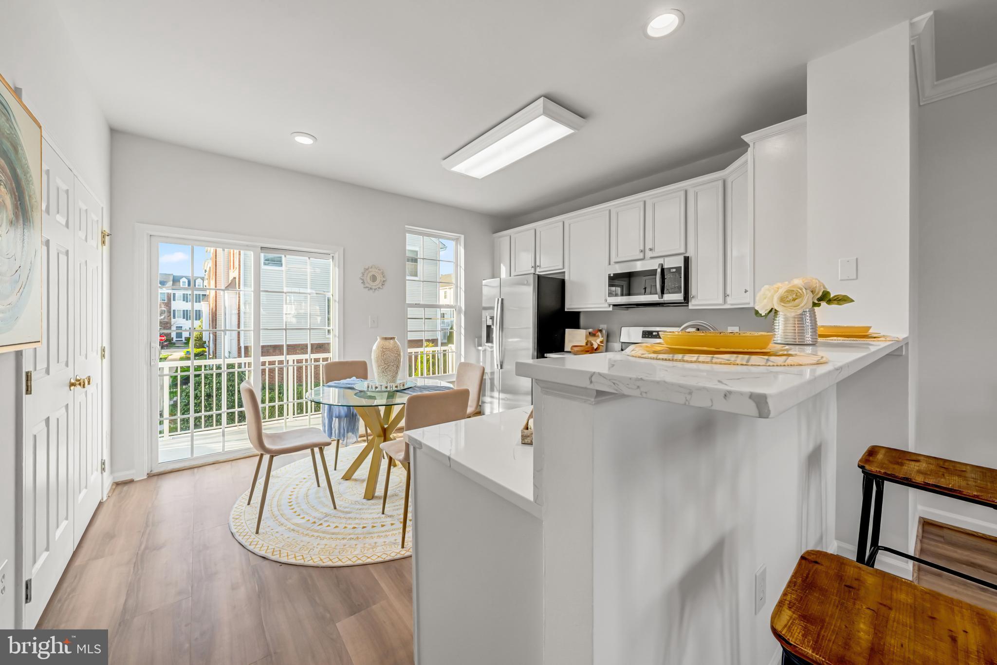 42790 Nations Street Chantilly, VA 20152 - Photo 22 of 40 a kitchen with stainless steel appliances granite countertop a stove a refrigerator a sink a dining table and chairs with wooden floor