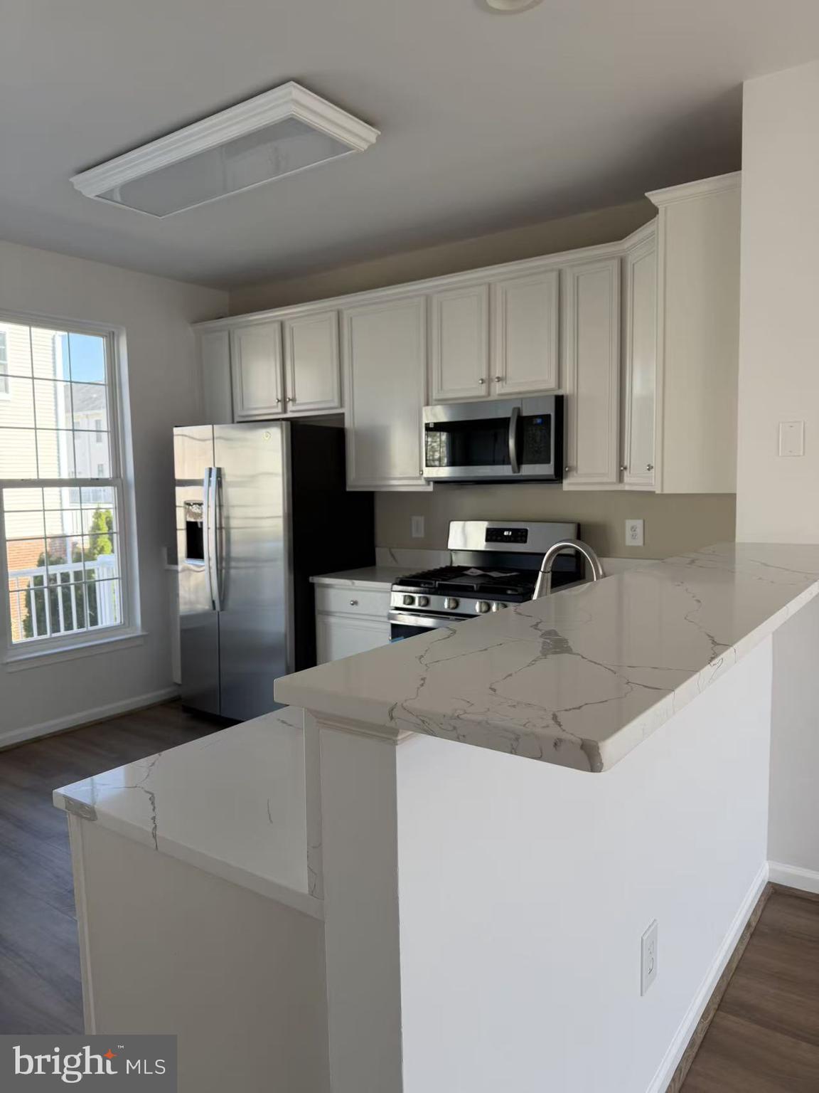 42790 Nations Street Chantilly, VA 20152 - Photo 4 of 40 a kitchen with stainless steel appliances granite countertop a refrigerator a stove a sink a microwave and white cabinets