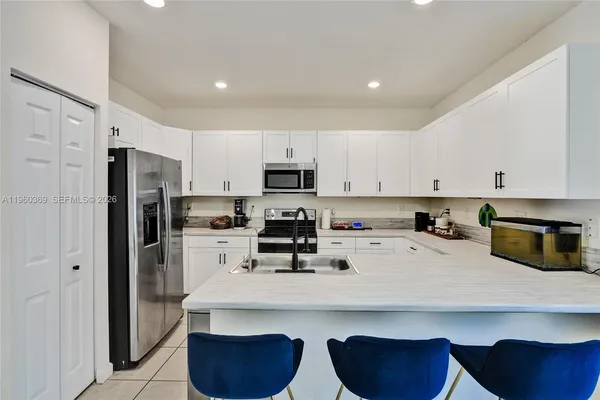 a kitchen with stainless steel appliances a refrigerator sink and microwave
