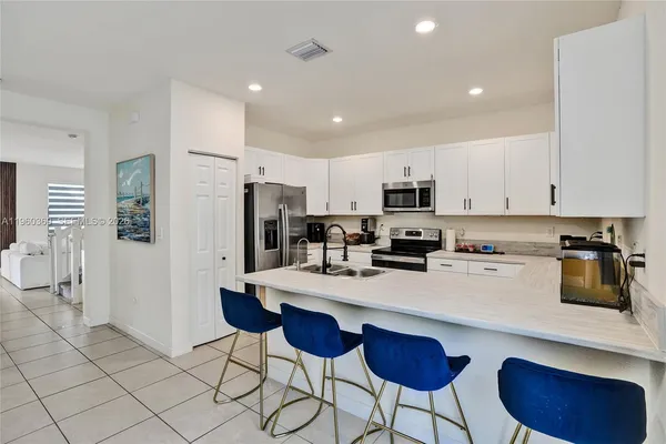 a kitchen with stainless steel appliances a stove refrigerator sink and cabinets