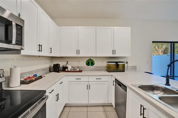 a kitchen with white cabinets and white appliances