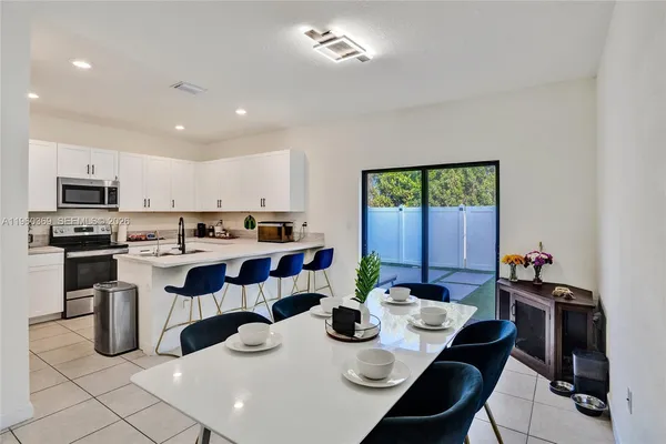 a kitchen with a sink dining table and chairs