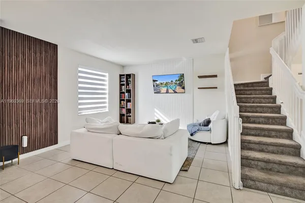 a living room with furniture and stairs
