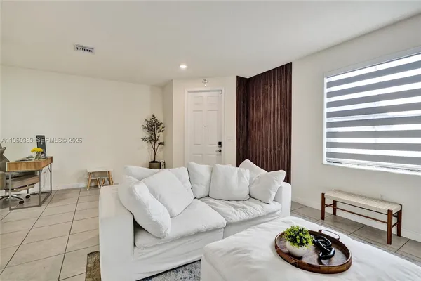 a living room with furniture and a potted plant