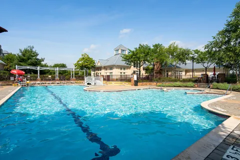a view of a swimming pool with lawn chairs under an umbrella