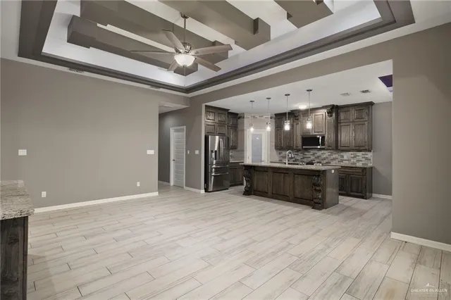 a large kitchen with a counter space a sink and stainless steel appliances