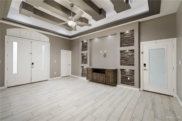 an empty room with wooden floor closet and windows