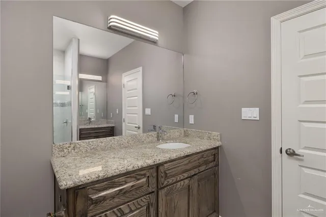 a bathroom with a granite countertop sink and a mirror