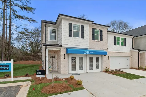a front view of a house with garden and plants
