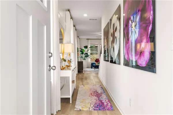 a view of a hallway with wooden floor and couches