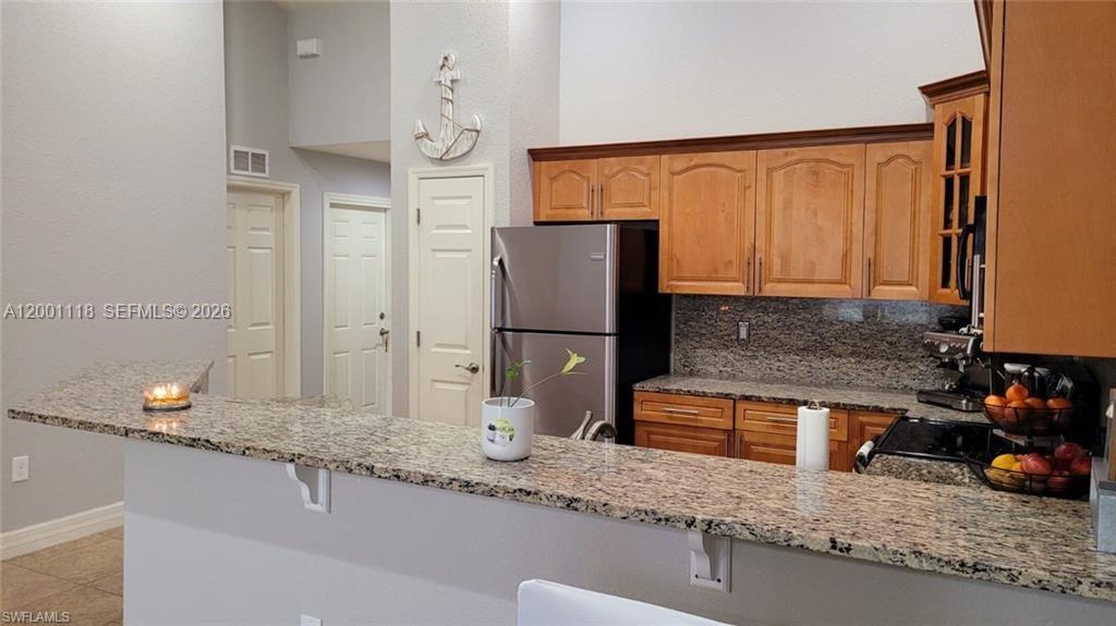 152 Pullman Street, Unit 152 Lehigh Acres, FL 33974 - Photo 6 of 15 a kitchen with granite countertop a refrigerator and a sink