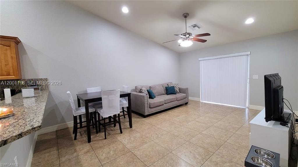 152 Pullman Street, Unit 152 Lehigh Acres, FL 33974 - Photo 7 of 15 a living room with furniture and a flat screen tv